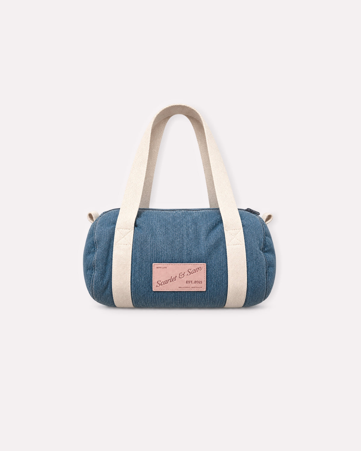 Denim Padded Barrel Tote, front view, showing cream canvas handles and the Scarlet & Sam logo patch.