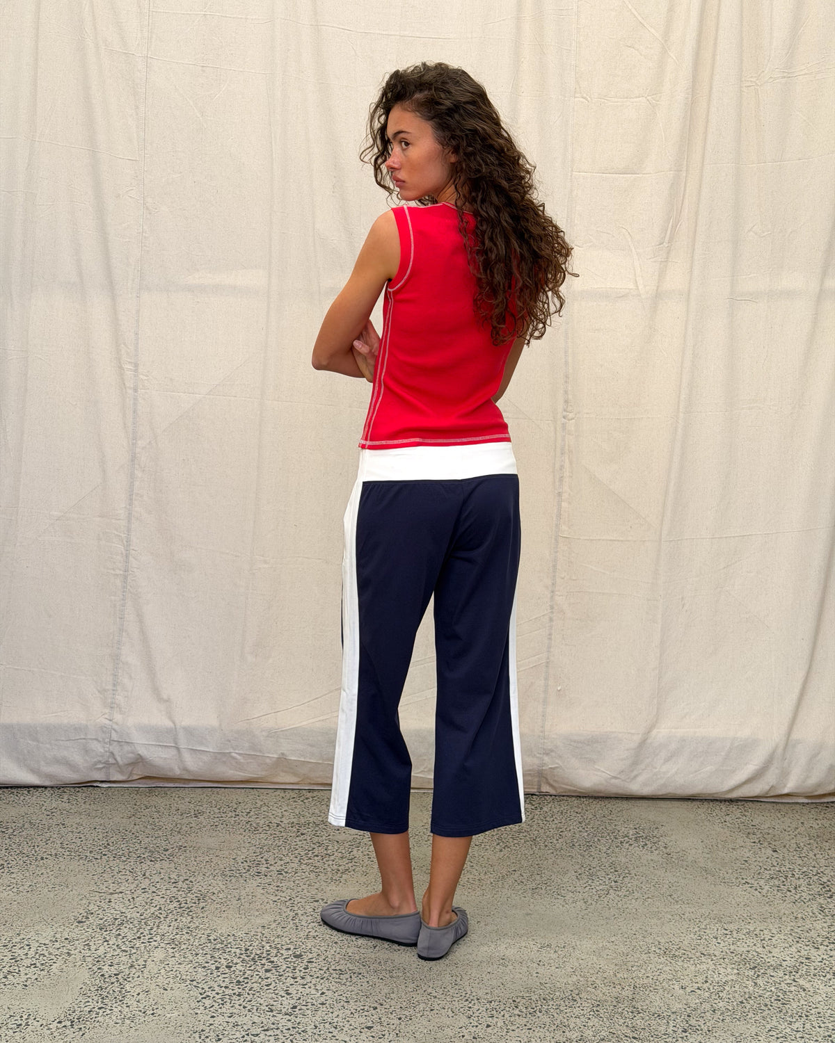 model:S/8AU H:179CM 
Navy Jersey Capri pants, back view on a model, showing the white waistband, side stripes and cropped wide legs.