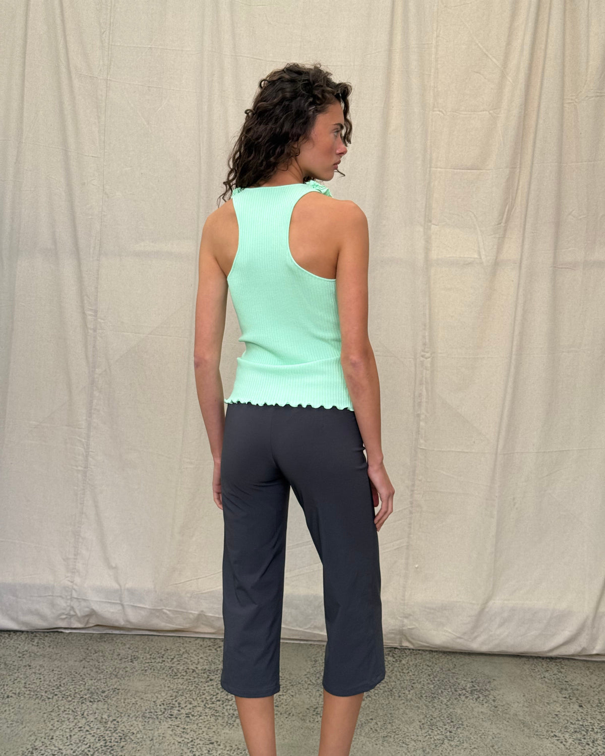 model:XS/6AU
Back view of the mint Ruffle Knit Tank, showing its racerback shape, fitted ribbed knit and lettuce-edge hem.