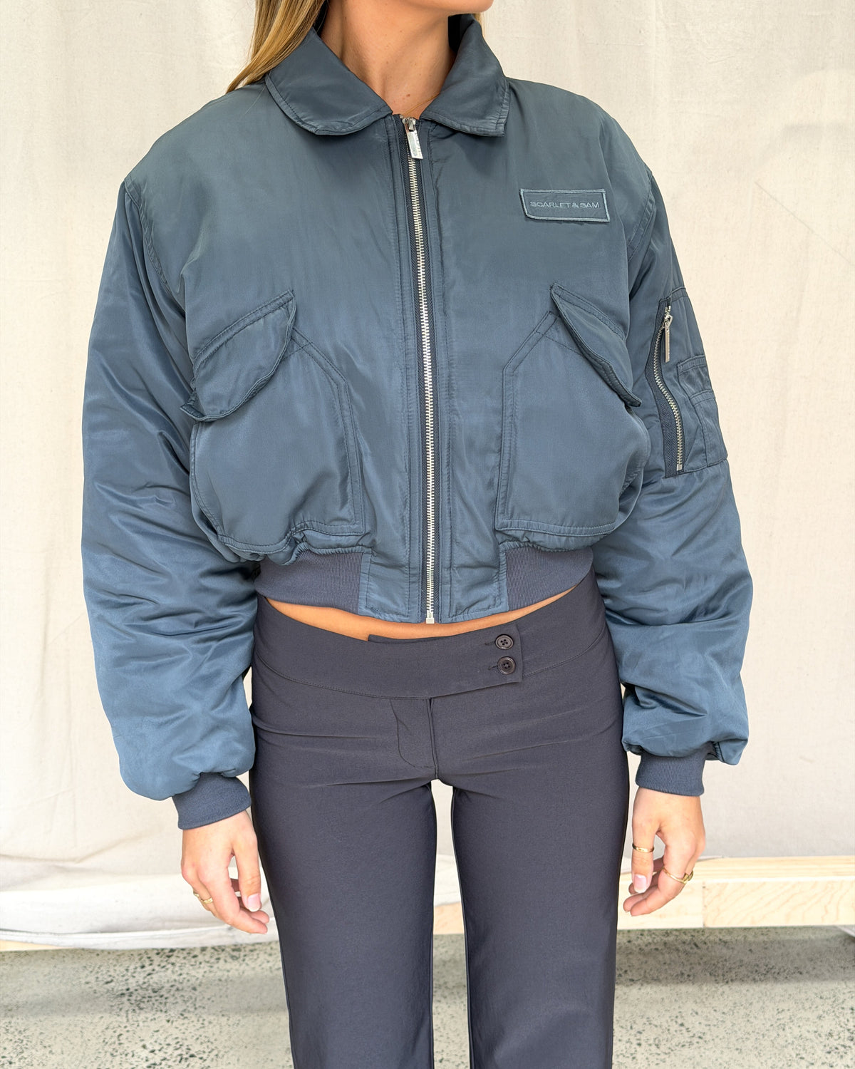 model:S/M/6-10AU H:173CM 
Front view of the charcoal Capsule Bomber zipped up, showing the cropped shape and ribbed hem.