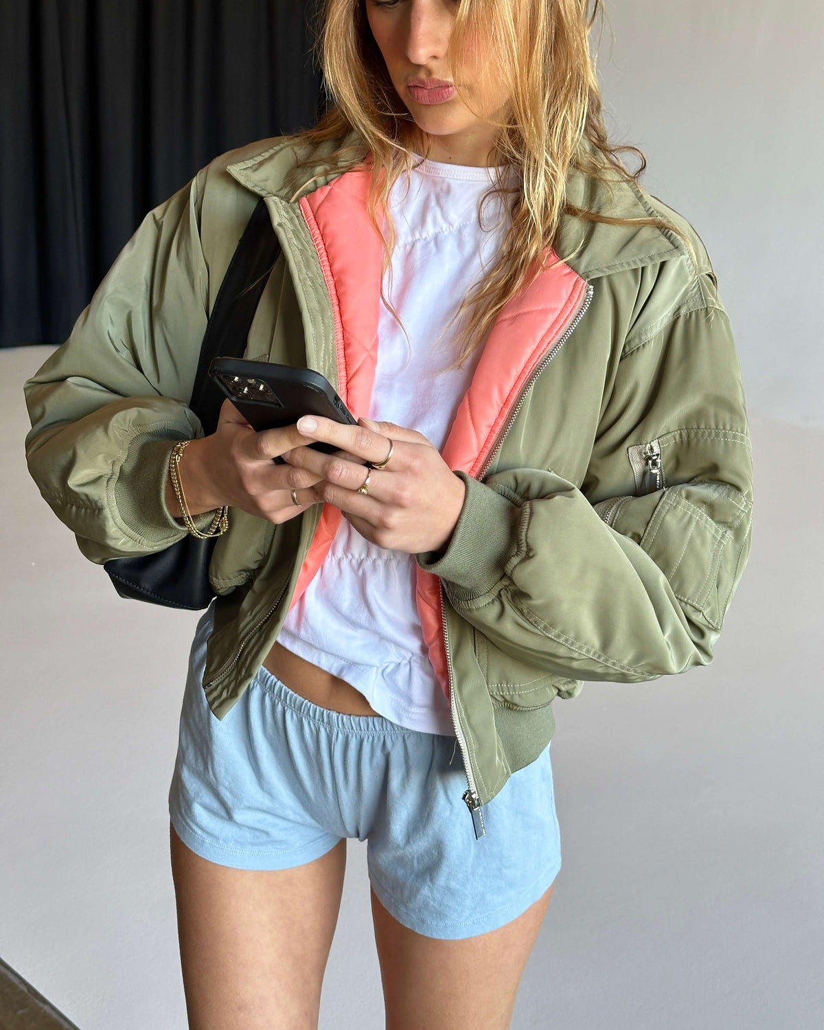 model:S/M/6-10AU H:171CM 
Khaki Capsule Bomber, worn open, revealing the pink lining.