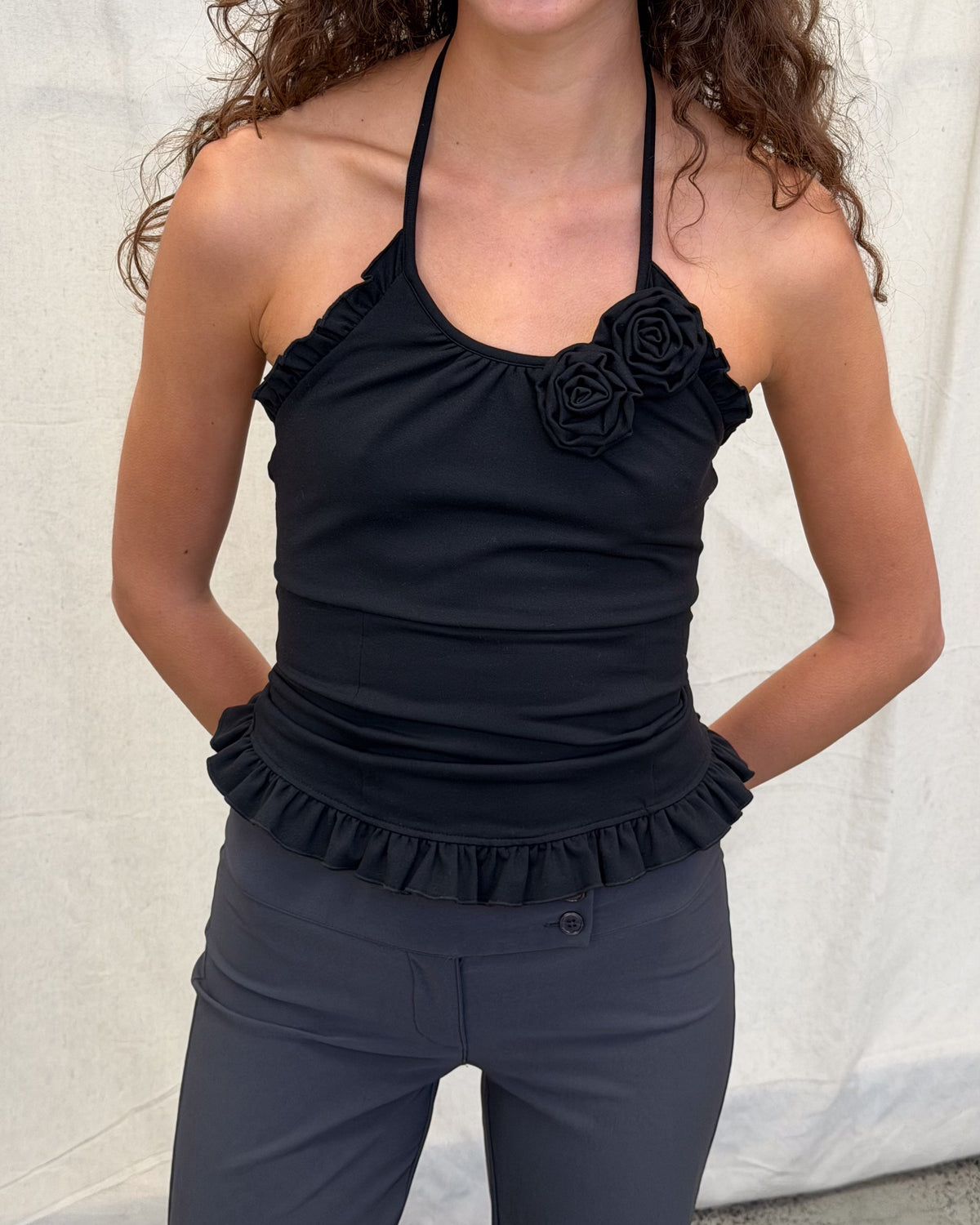 model:XS/6AU H:179CM 
Black Rose Sculpt Halter, close front view of the rosette neckline and ruffled hem.