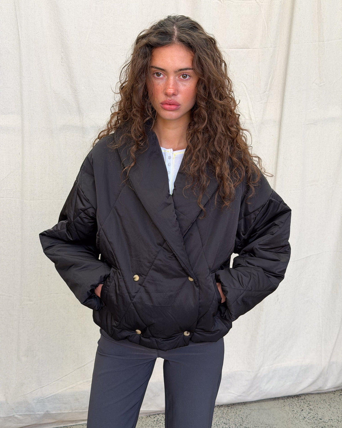 model:XS/6AU H:179CM 
Black Cocoon Padded Jacket, front view on a model, showing the oversized shawl collar, gold-tone snaps and side pockets.