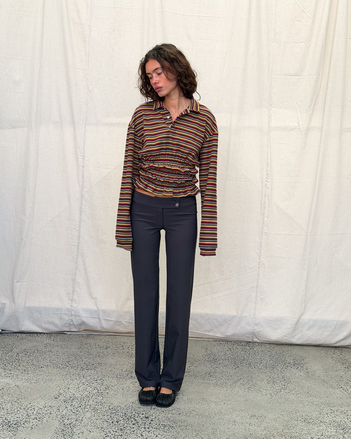 model:XS/6AU H:179CM 
Mustard stripe Eden Rugby Polo, front view on a model, showing the gathered waist and sleeves extending past the hands.