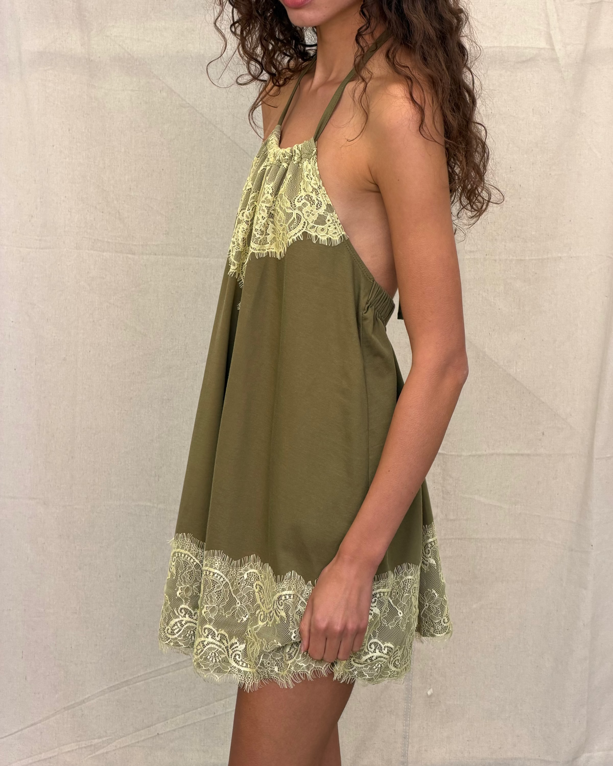 model:S/8AU H:179CM 
Khaki Jersey Lace Halter Dress, side close-up on a model, showing the low armhole, draped shape and contrast lace trim.