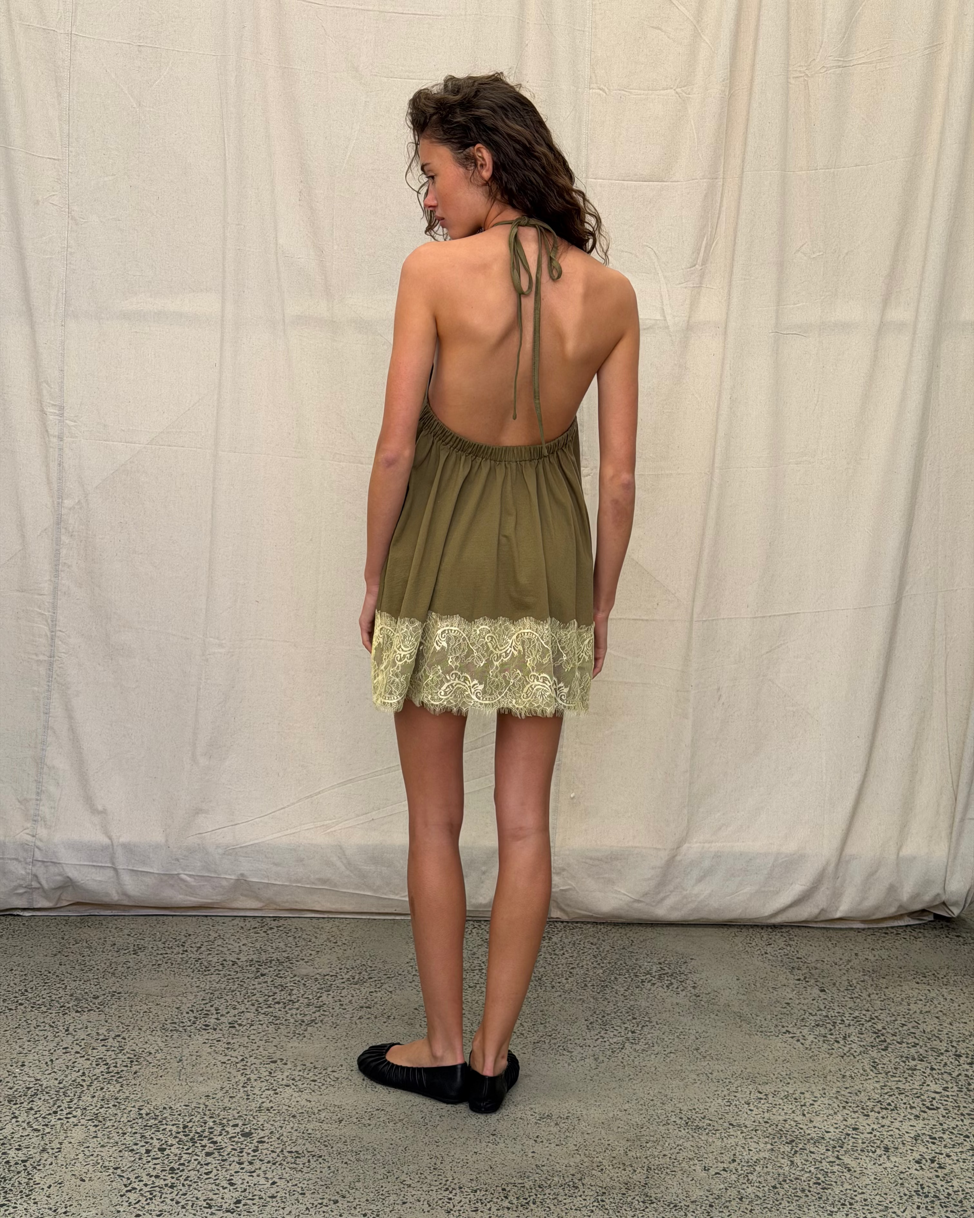 model:S/8AU H:179CM 
Khaki Jersey Lace Halter Dress, back view on a model, showing the adjustable neck tie, low open back and contrast lace hem.