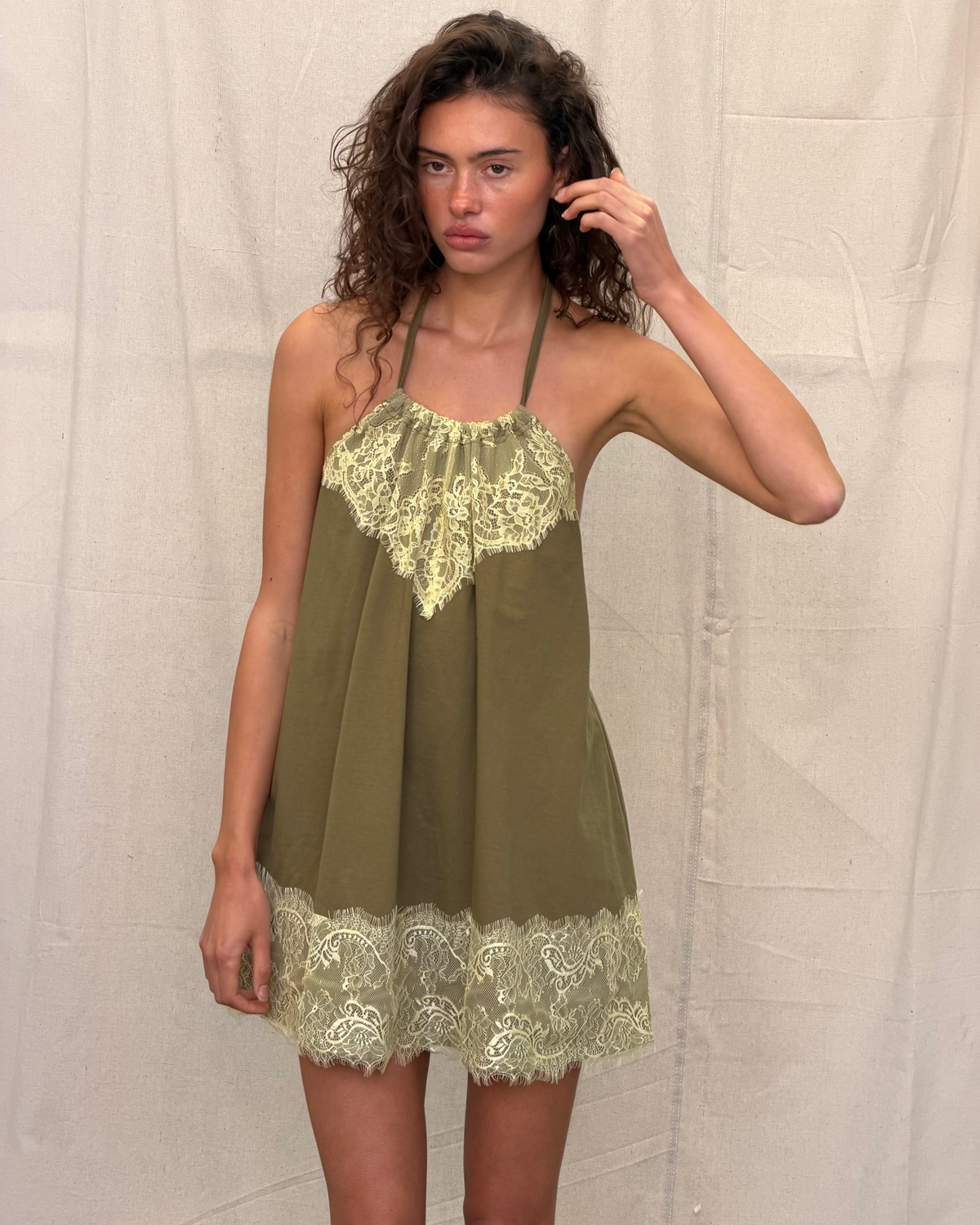model:S/8AU H:179CM 
Khaki Jersey Lace Halter Dress, front close-up on a model, showing the gathered lace neckline, loose shape and lace-trimmed short hem.