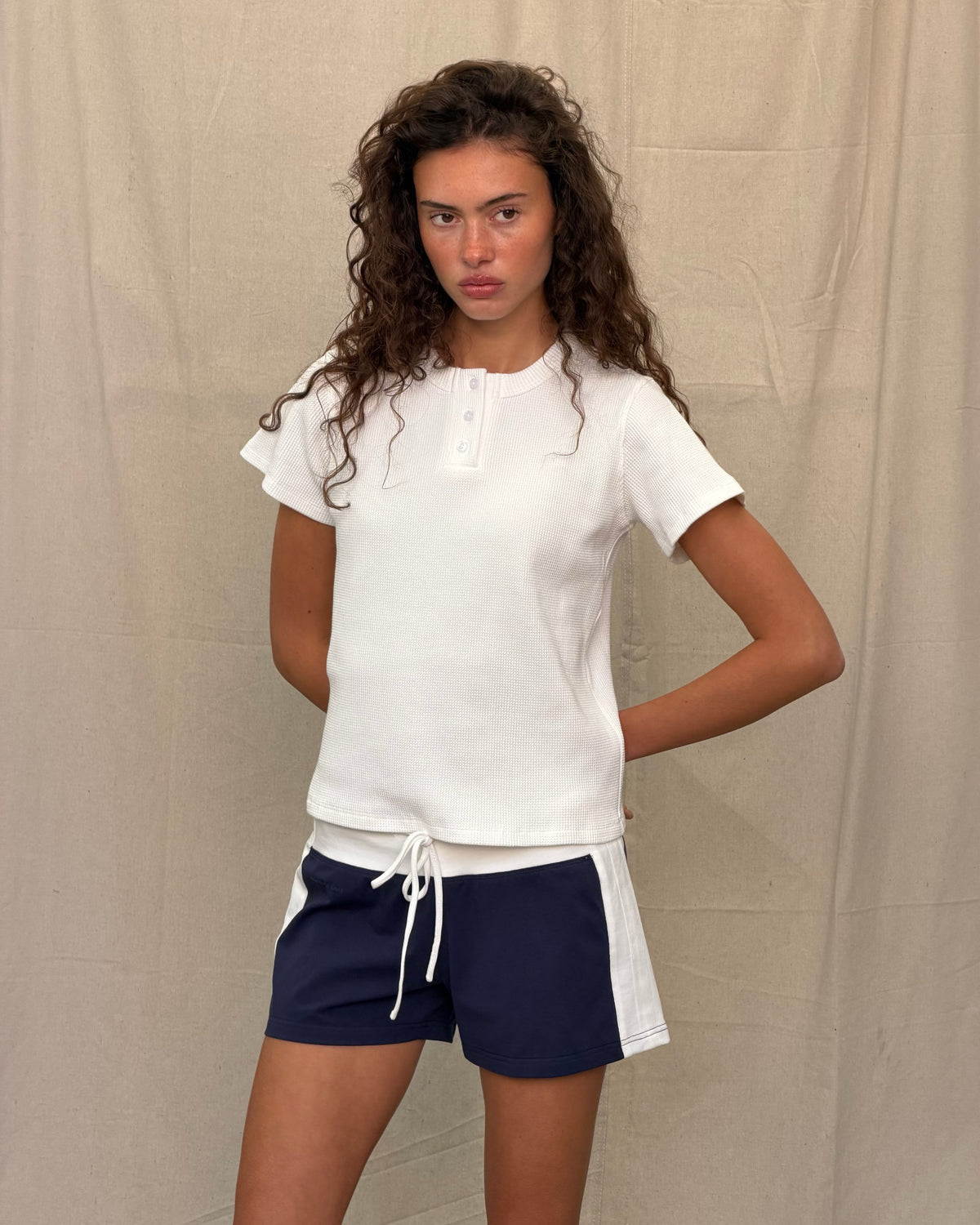 model:S/8AU H:179CM 
Scarlet & Sam white Waffle Tee styled on a model with black trousers and a tan shoulder bag.