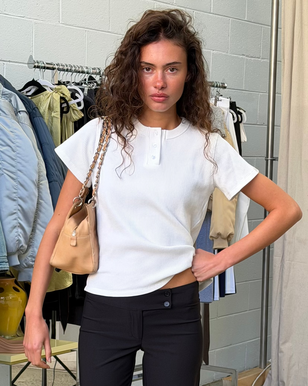 model:S/8AU H:179CM 
Scarlet & Sam white Waffle Tee styled on a model with black trousers and a tan shoulder bag.