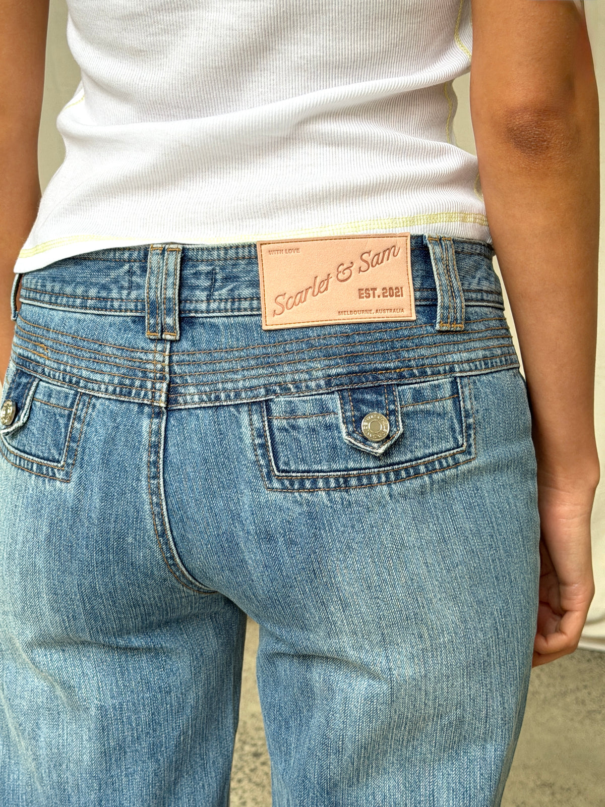 model:S/8AU 
Blue 90s Low Rise Jeans, close back view of the logo patch and pockets.
