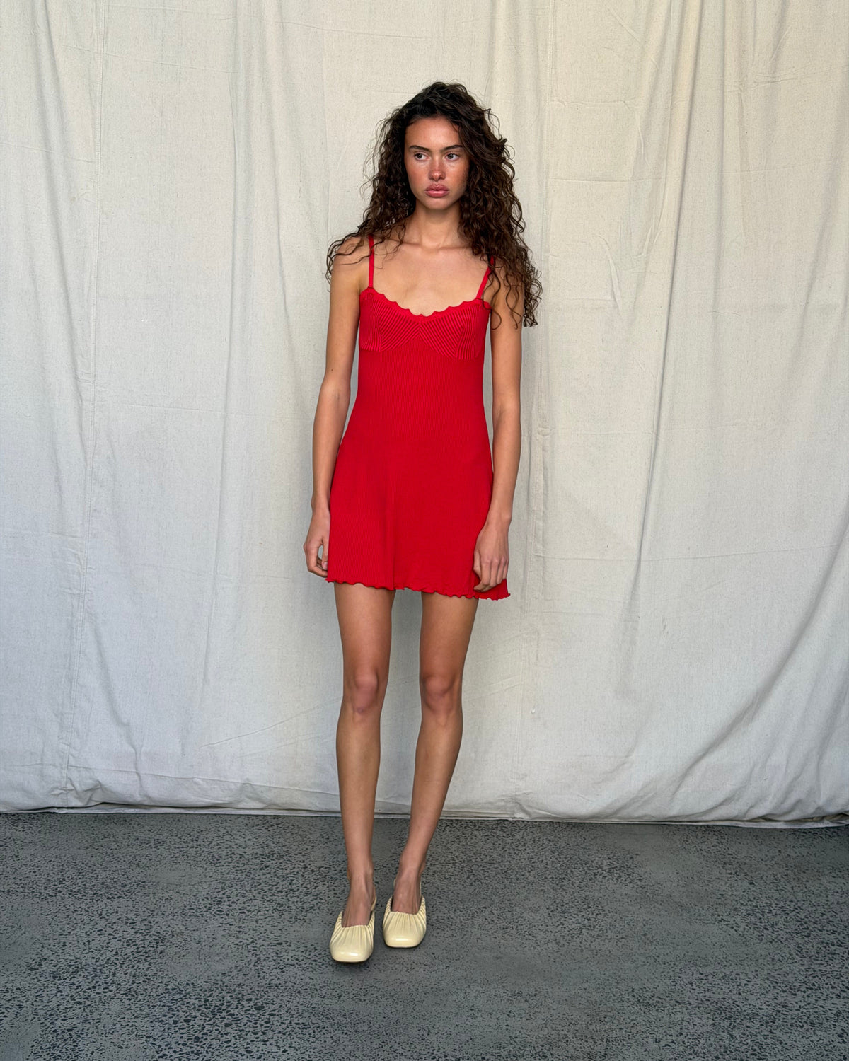 model:XS/6AU
Full-length front view of the red Ribbed Knit Dress, showing the fitted knitted bust and flared mini skirt with yellow flats.