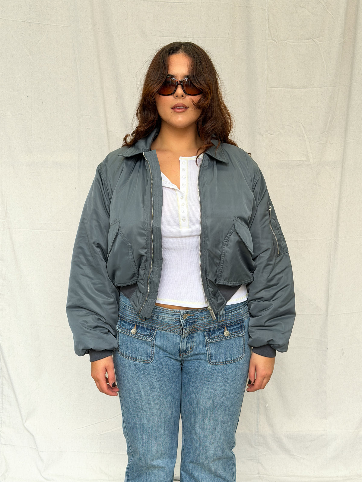 model:L/XL/12-16AU H:173CM 
Charcoal Capsule Bomber, front view, worn open with a white top and jeans.