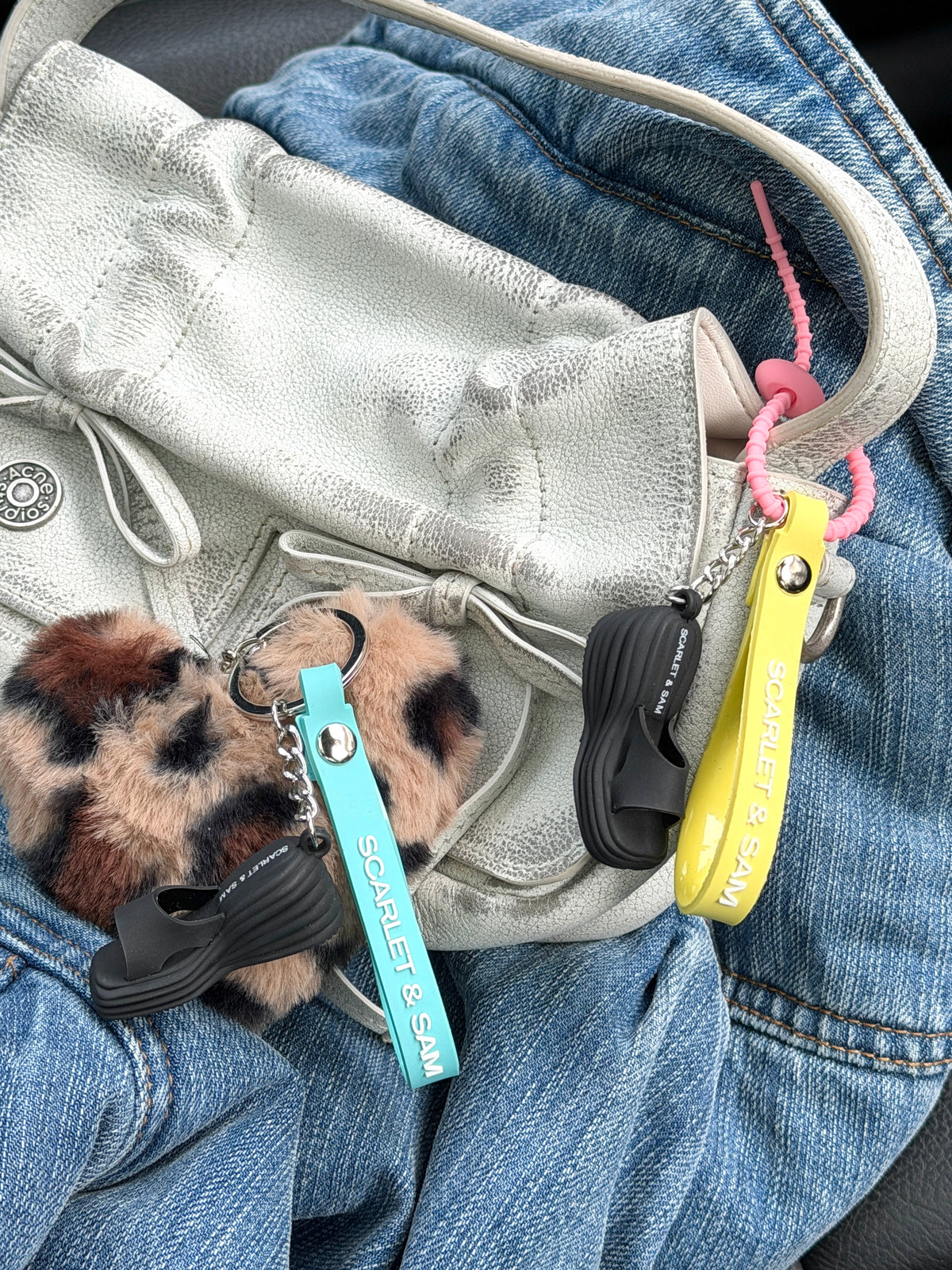 Juicy Wedge Keyring, attached to a silver bag beside a yellow bag charm.