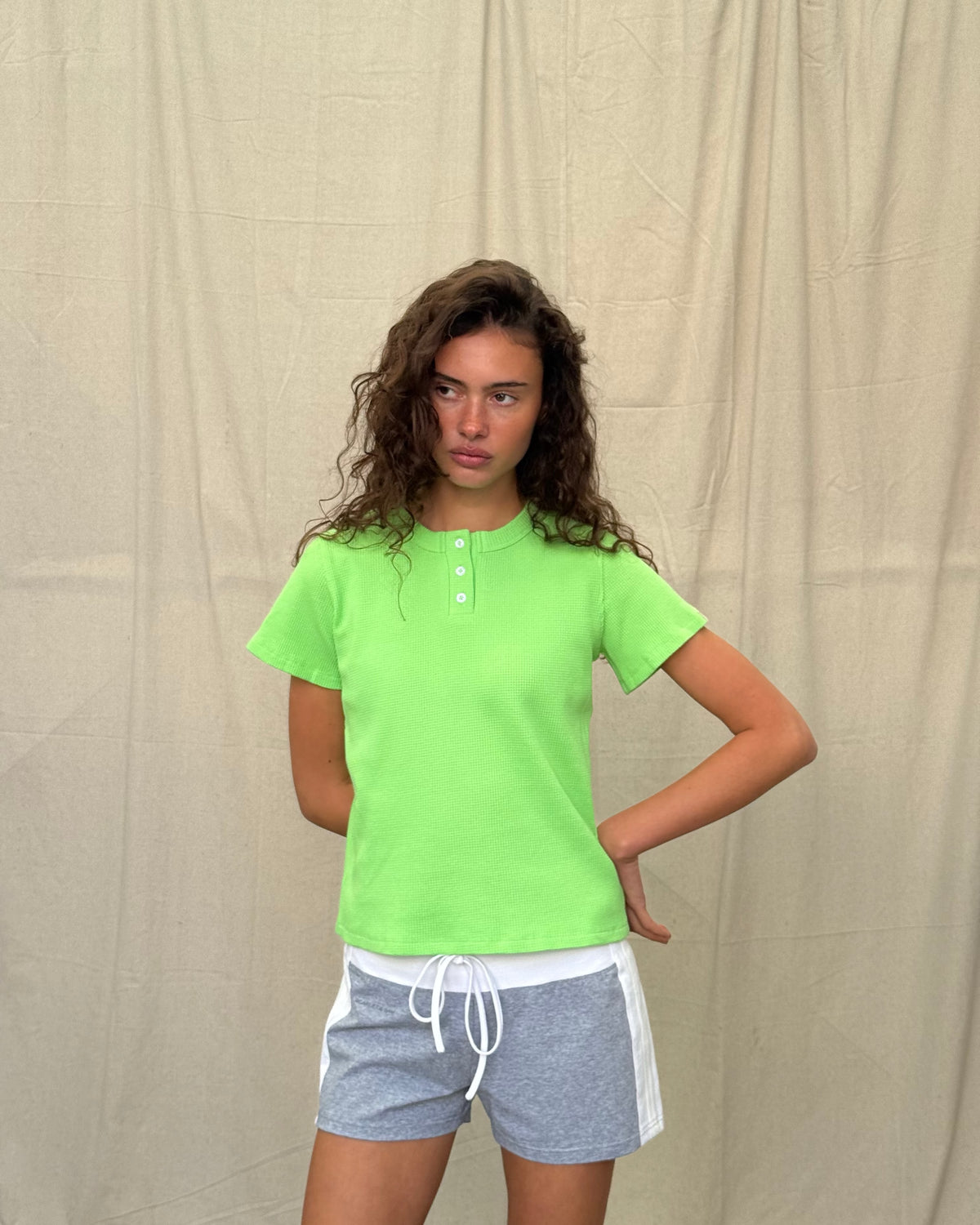 model:S/8AU H:179CM 
Scarlet & Sam apple green Waffle Tee, side view on a model looking towards the camera, showing the relaxed fit and sleeve tab.