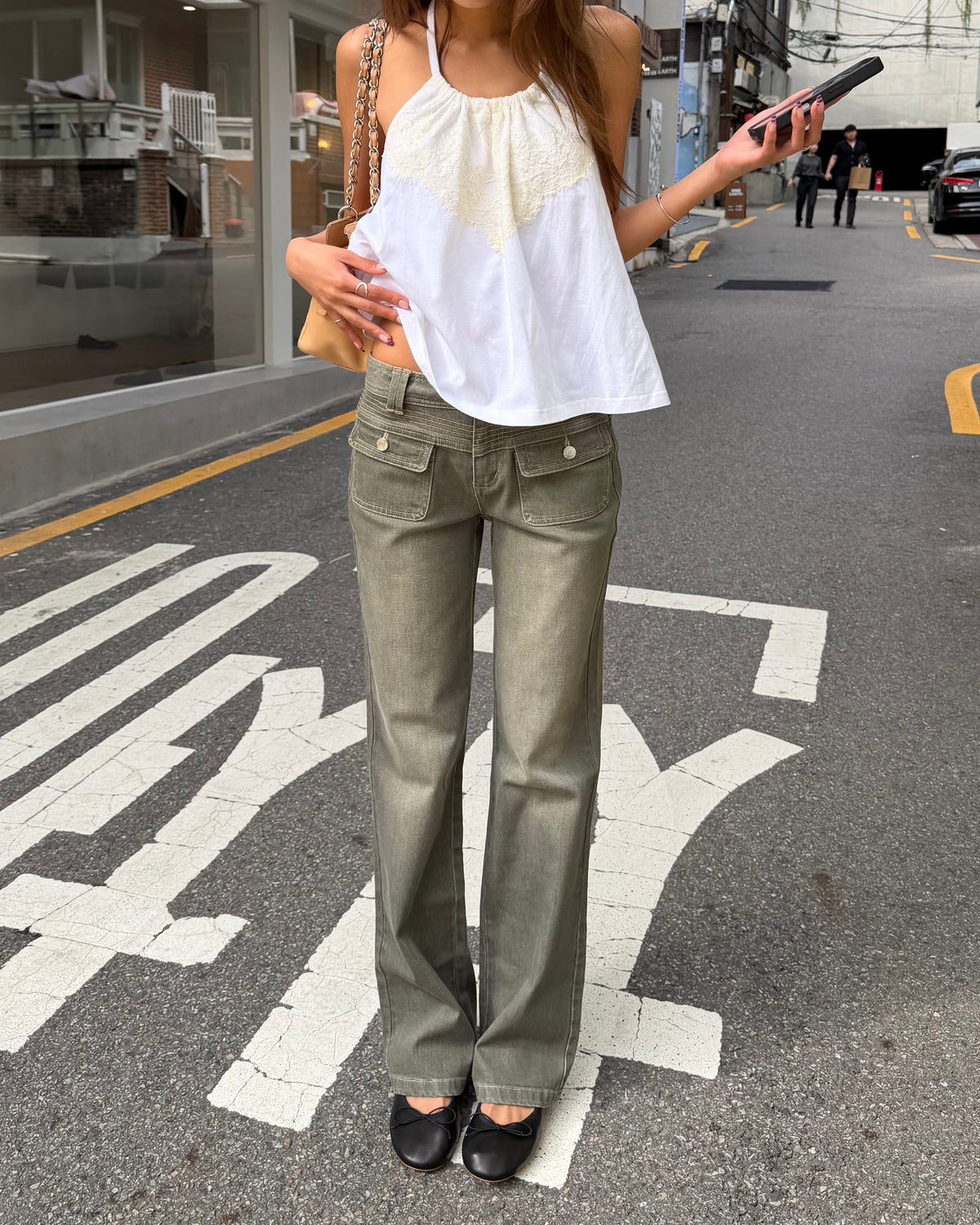 model:XS/6AU H:171CM
Front view of the khaki 90s Low Rise Jean, showing buttoned patch pockets and full-length straight legs with a white halter top.