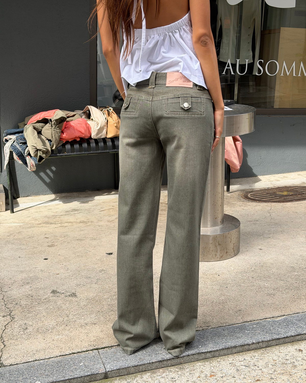 model:XS/6AU H:171CM
Back view of the khaki 90s Low Rise Jean, showing buttoned back pockets, pink waistband label and straight legs.