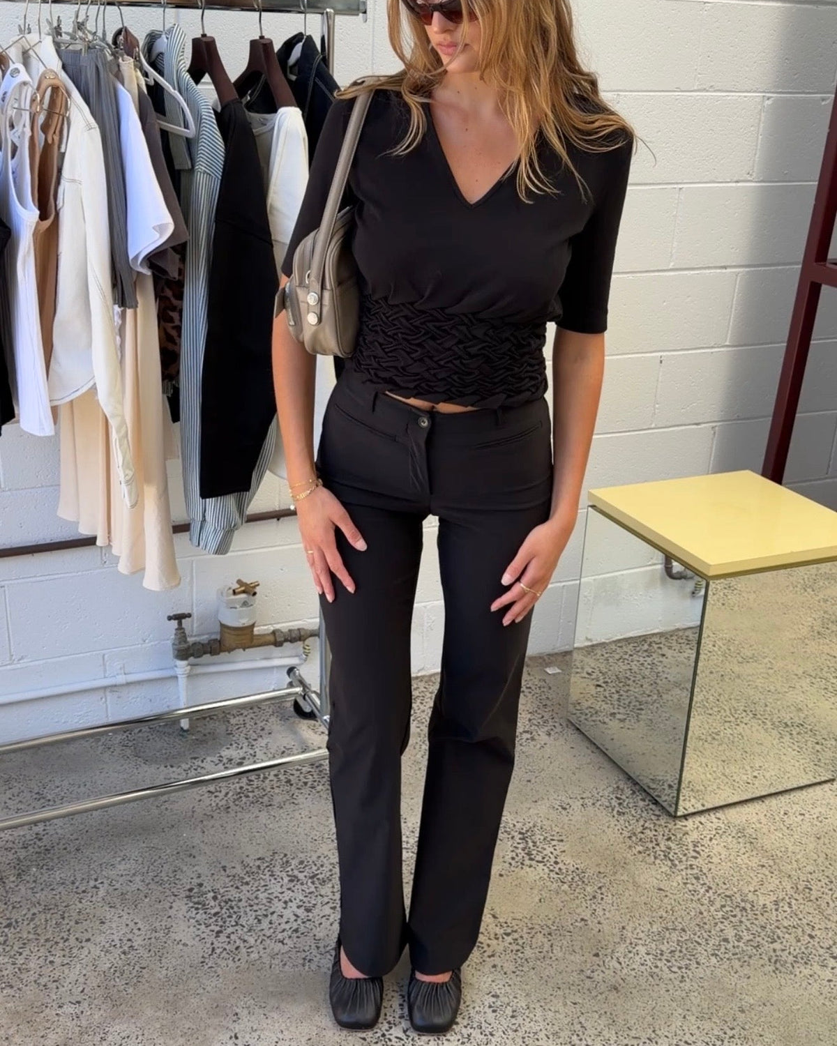 model:S/8AU H:171CM 
Black Capsule Pants, front view, styled with a black V-neck top.