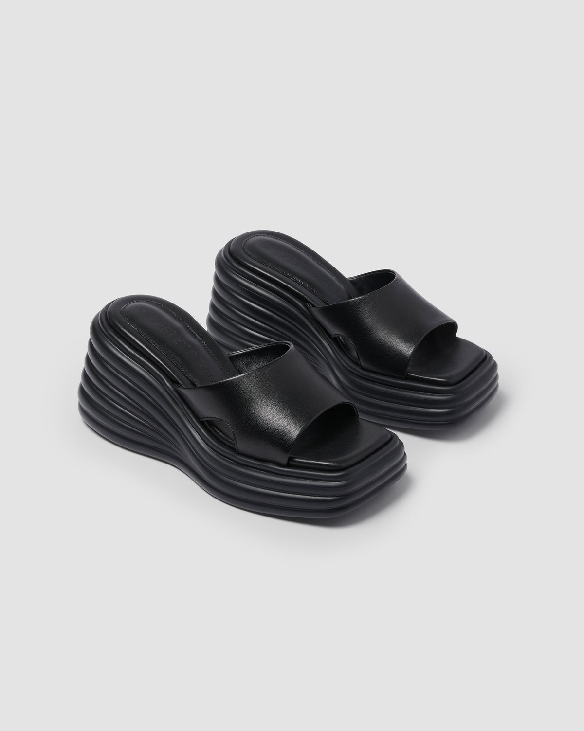 Black Juicy Wedge, pair photographed at an angle to show the sculpted soles.