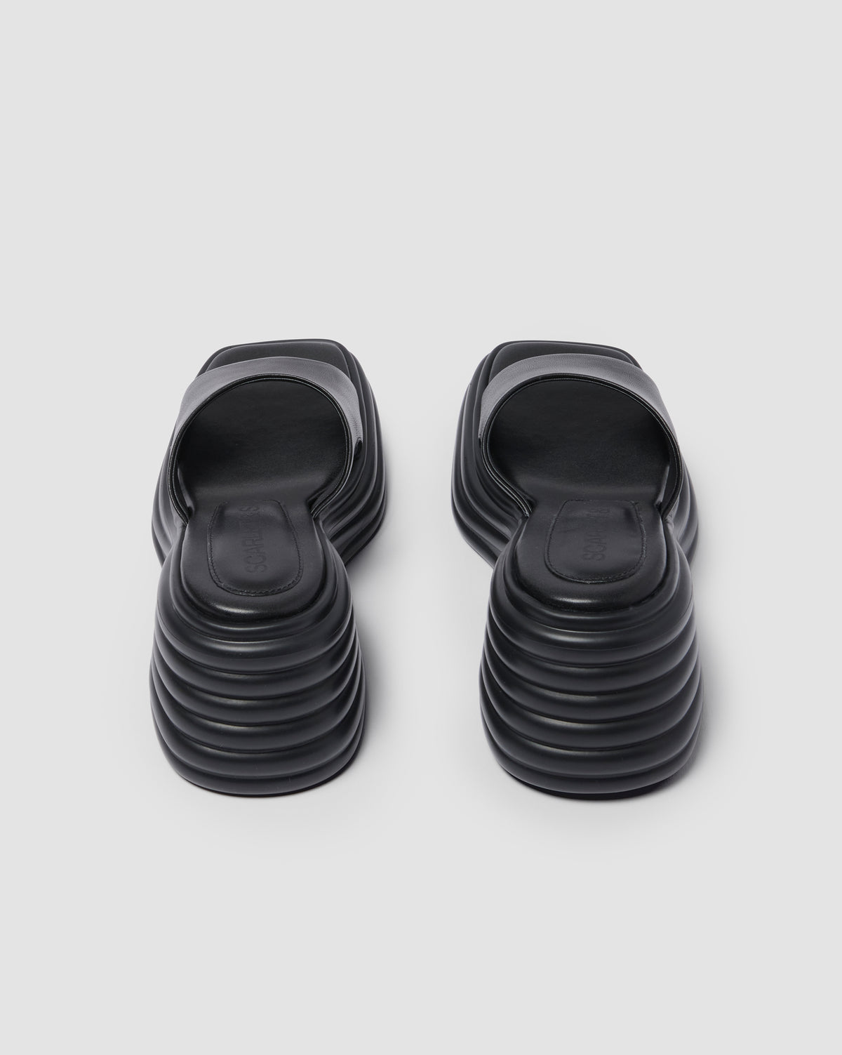 Black Juicy Wedge, pair viewed from behind, showing the ridged wedge heels.