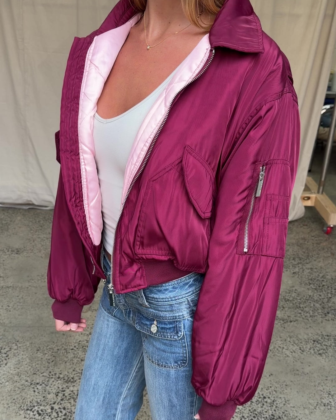 Video preview: Plum Capsule Bomber, worn open, showing the front pockets and sleeve zip pocket.